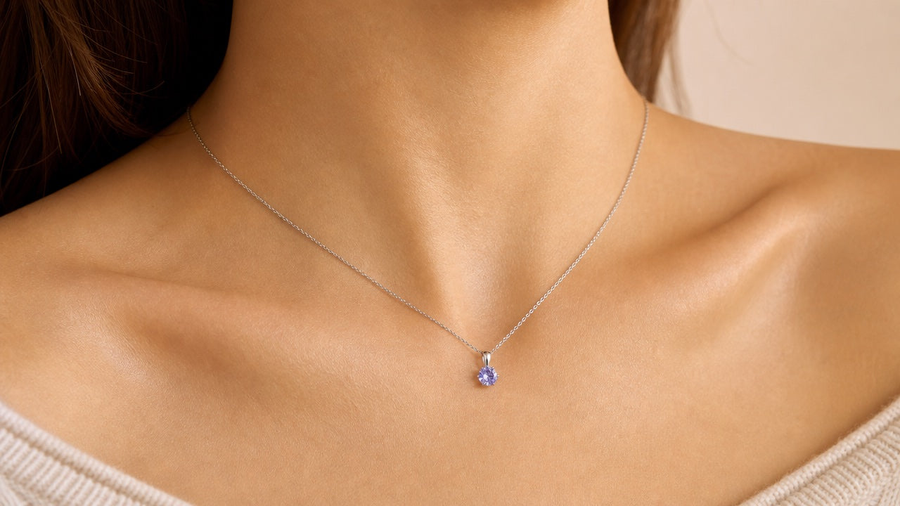 Delicate silver chain necklace with lavender crystal pendant worn on a neck
