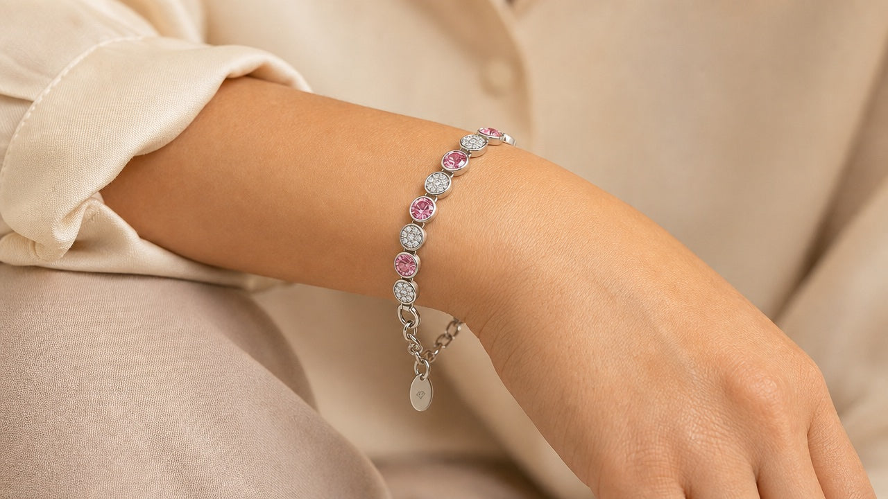 Silver and pink crystal tennis bracelet worn on a wrist