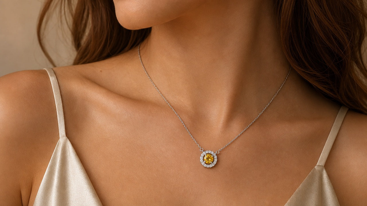Silver halo pendant necklace with yellow stone worn on a neck